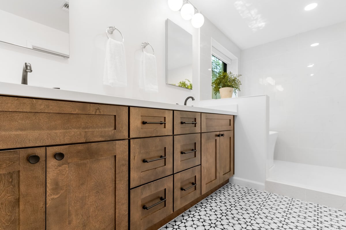 Natural wood double sink cabinetry in bright custom bathroom by Trinity Homes AZ in Gilbert, AZ