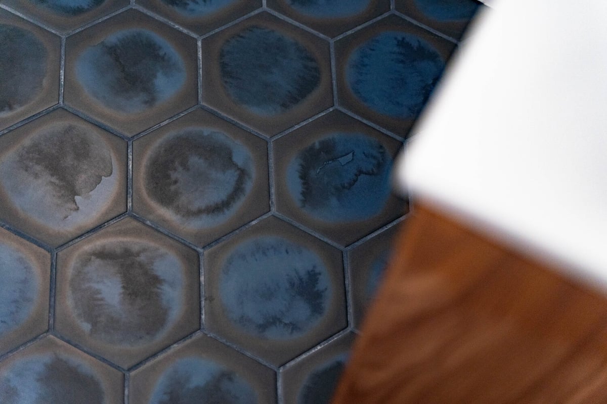 Close-up of blue hexagon floor tile in a custom bathroom by Trinity Homes AZ in Phoenix, AZ