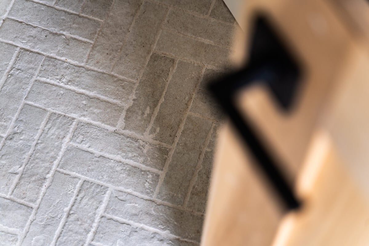 Close-up of rustic herringbone pattern tile flooring in a Trinity Homes AZ custom home in Tempe, AZ