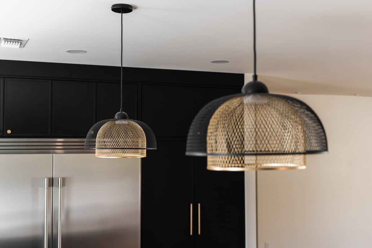 Woven rattan-style pendant lights over kitchen island in Trinity Homes AZ remodel, Scottsdale, AZ