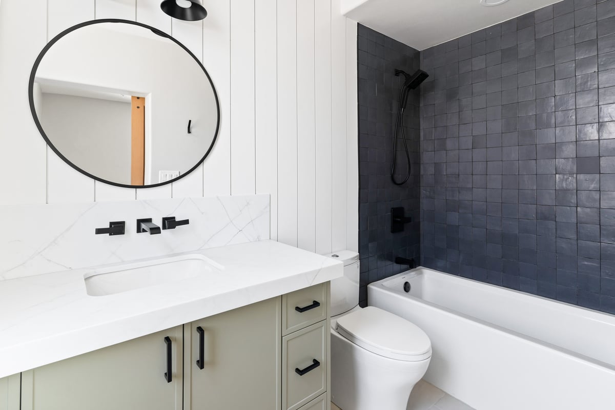 Custom bathroom remodel with black fixtures and blue tile in Phoenix, AZ by Trinity Homes AZ