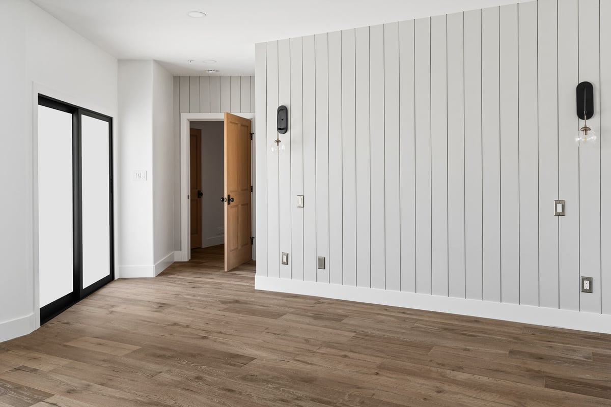 Custom bedroom with vertical paneling and modern light fixtures in Chandler home by Trinity Homes AZ