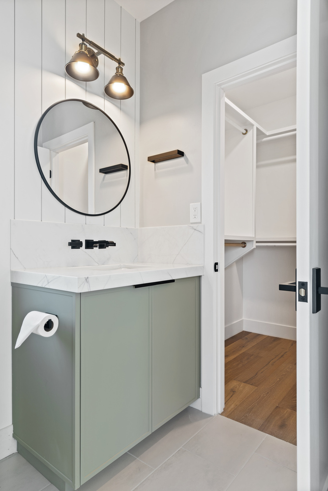 Custom powder room featuring green vanity and wall-mounted faucet by Trinity Homes AZ in Arcadia, AZ