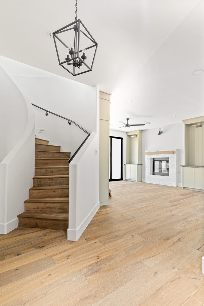 Custom staircase and open living area with fireplace by Trinity Homes AZ in Gilbert, AZ