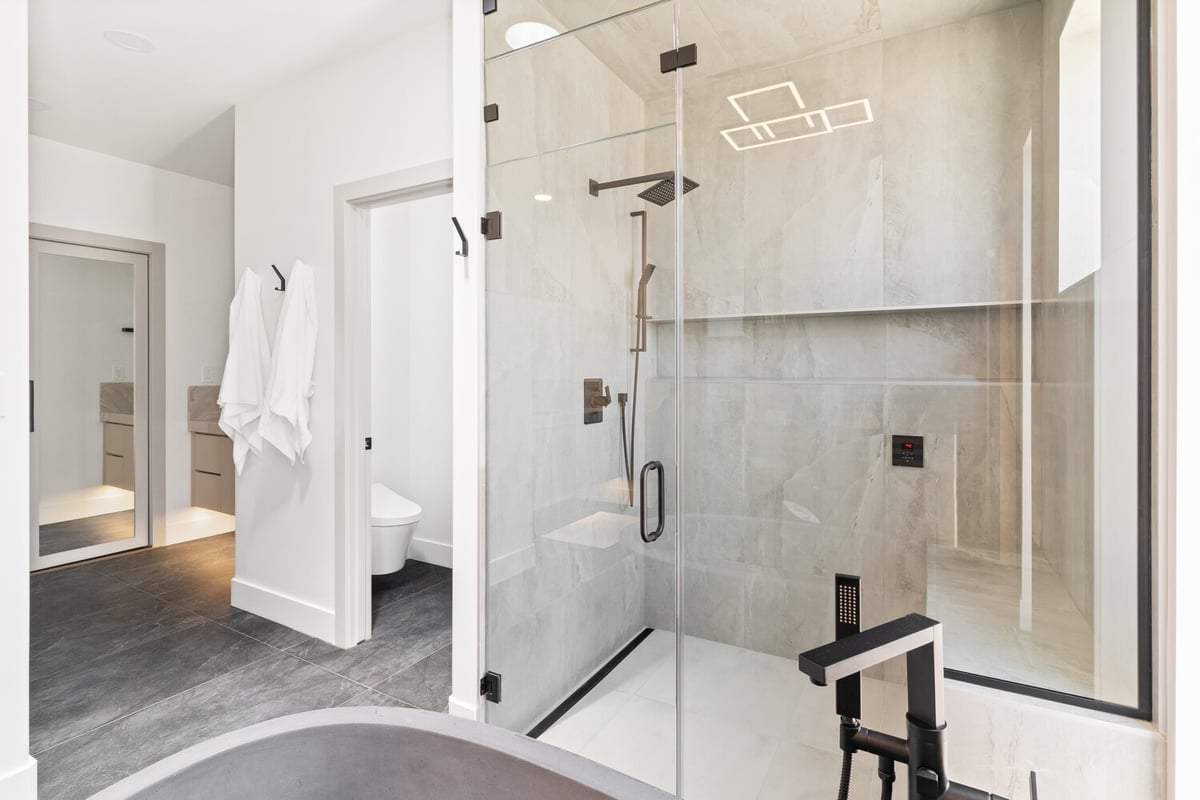 Luxurious custom bathroom shower with floor-to-ceiling tile by Trinity Homes AZ in Phoenix, AZ
