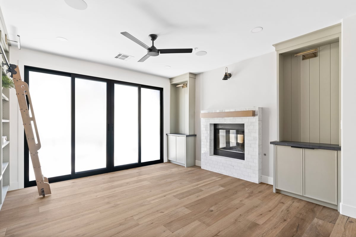 Modern living area with sliding glass doors and tile fireplace in a Scottsdale, AZ custom home by Trinity Homes AZ