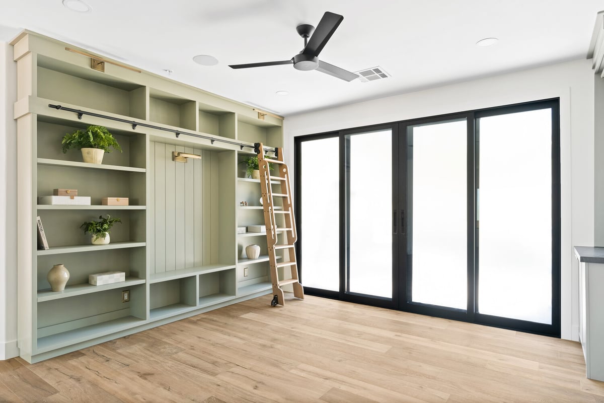 Open concept space with built-in shelving and large sliding doors by Trinity Homes AZ in Scottsdale, AZ