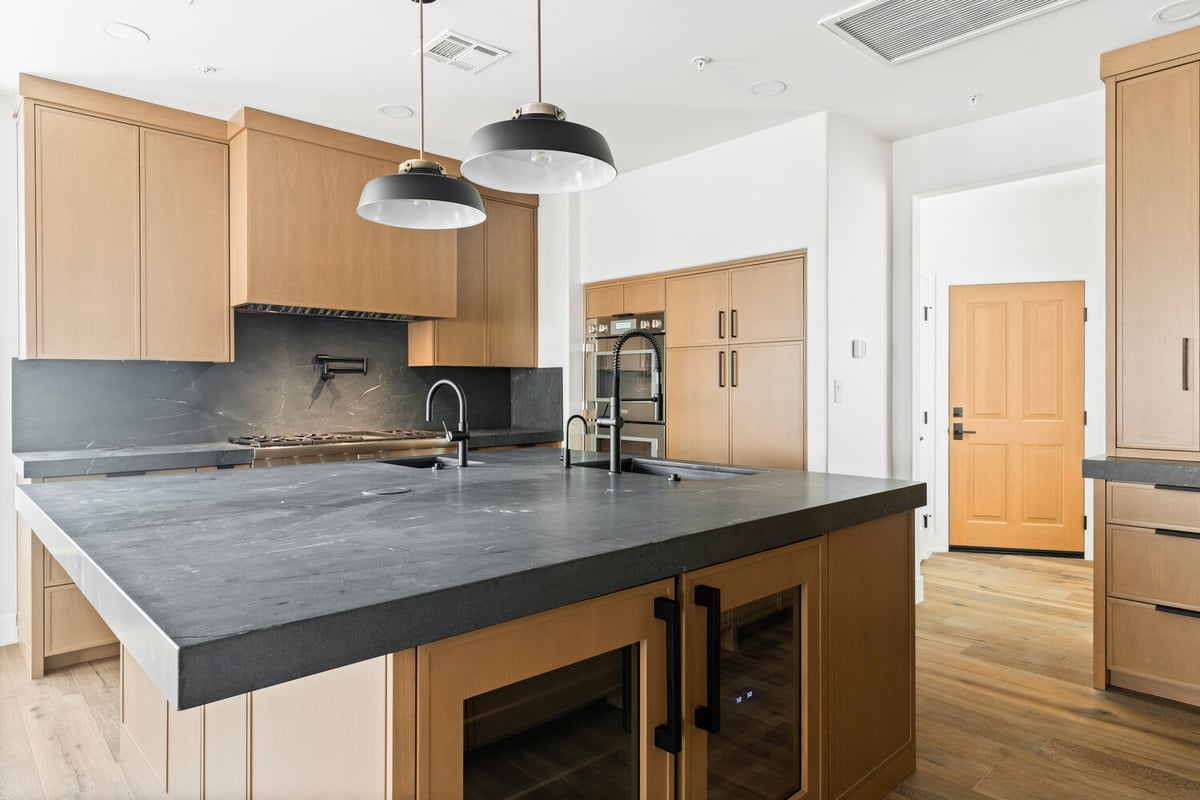 Open-concept kitchen with pendant lights and black faucet by Trinity Homes AZ in Paradise Valley, AZ