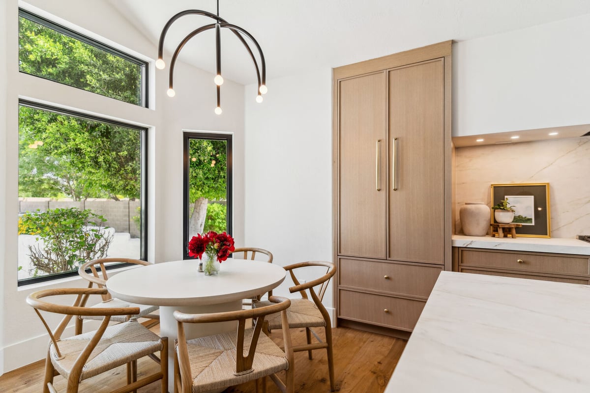 Bright breakfast nook with modern light fixture and large windows in Trinity Homes remodel, Gilbert, AZ
