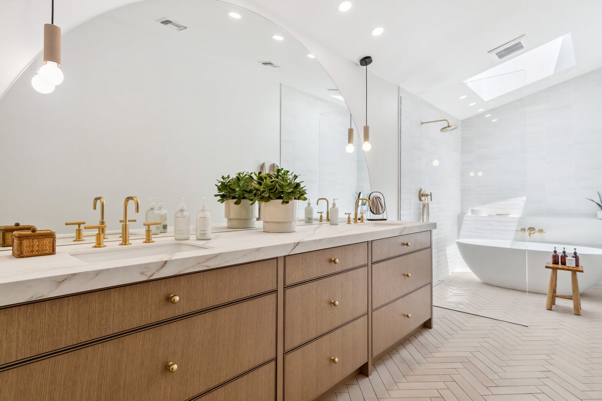 Double vanity bathroom remodel with brass fixtures in Trinity Homes Gilbert, AZ whole home project