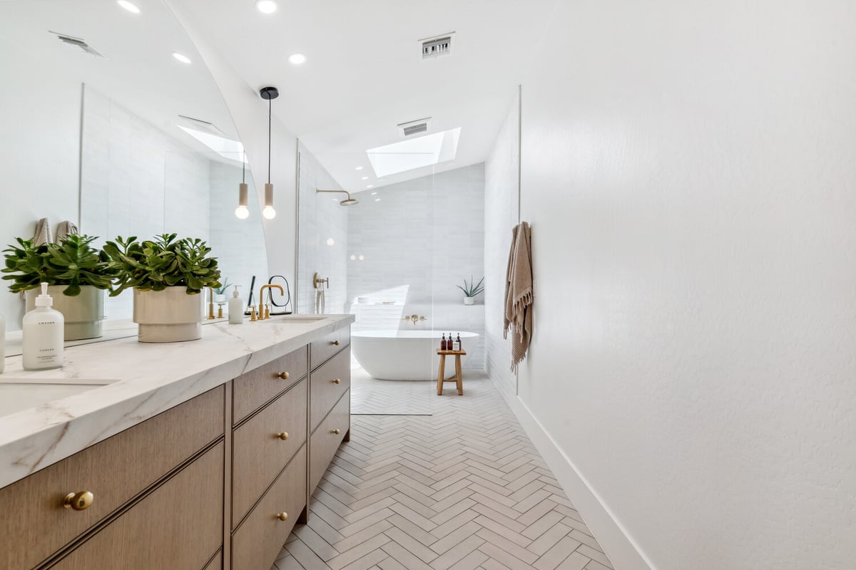 Spa-style master bathroom with soaking tub and skylight by Trinity Homes in Gilbert, AZ