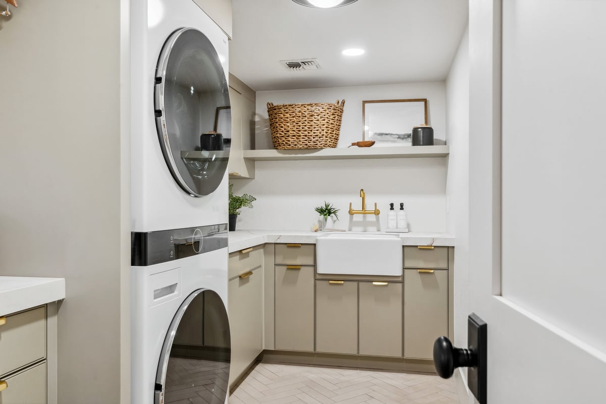 Updated laundry space with shaker cabinets and brass hardware by Trinity Homes in Gilbert, AZ