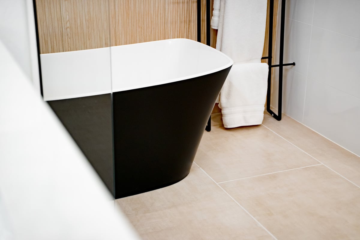 Freestanding black and white modern bathtub in remodeled Phoenix, AZ bathroom by Trinity Homes