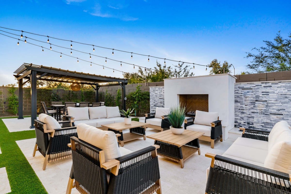 Phoenix patio remodel by Trinity Homes with cushioned seating and fireplace accent wall