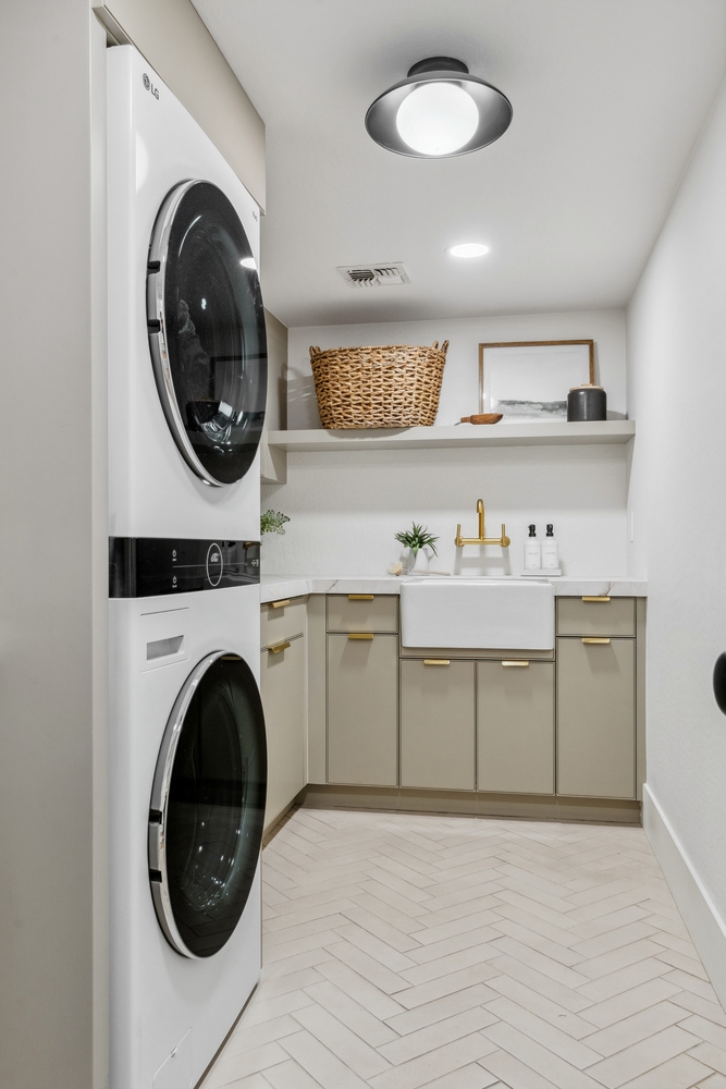 Clean and modern laundry room with neutral cabinetry in a Trinity Homes remodel in Gilbert, AZ