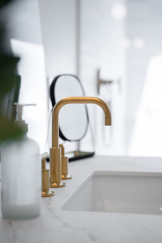 Matte gold bathroom faucet in custom remodel by Trinity Homes in Gilbert, AZ