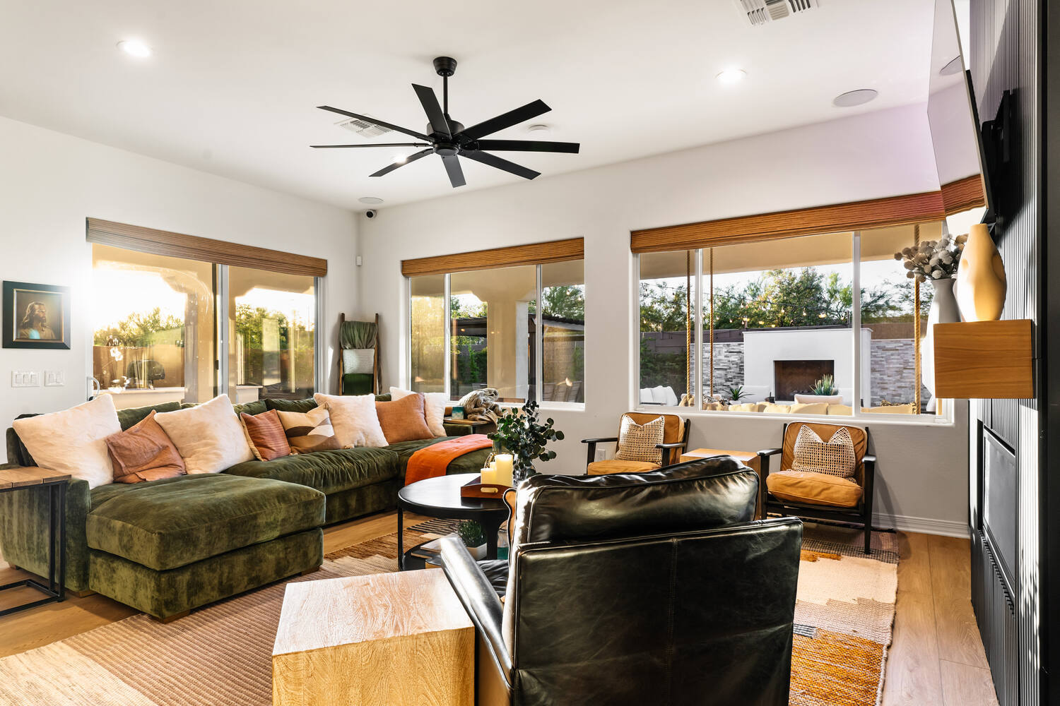 Living room remodel in Phoenix featuring green sectional and oversized ceiling fan by Trinity Homes