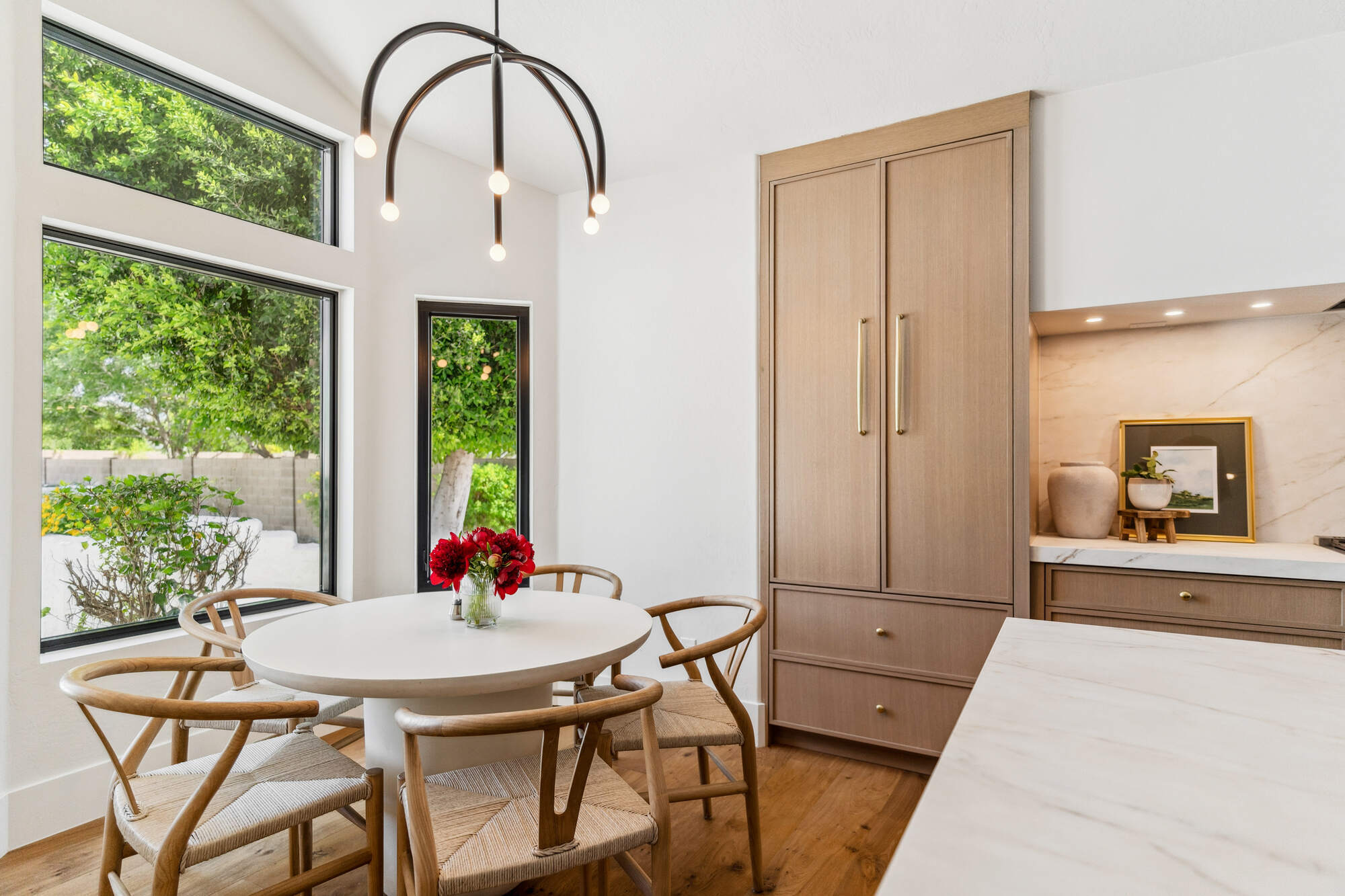 Bright breakfast nook with modern light fixture and large windows in Trinity Homes remodel, Gilbert, AZ