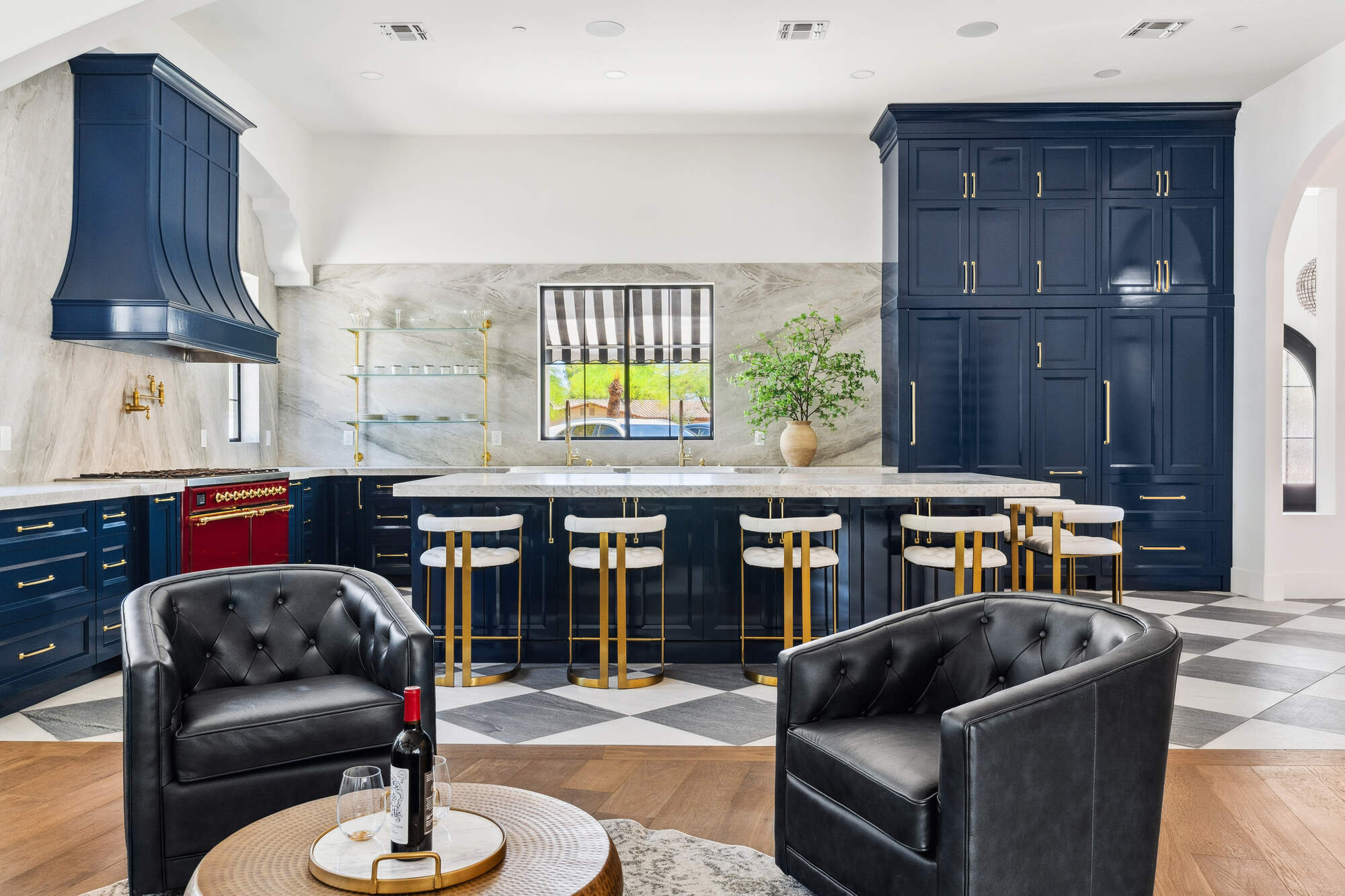 Full kitchen view with navy cabinets and marble backsplash in Scottsdale remodel by Trinity Homes
