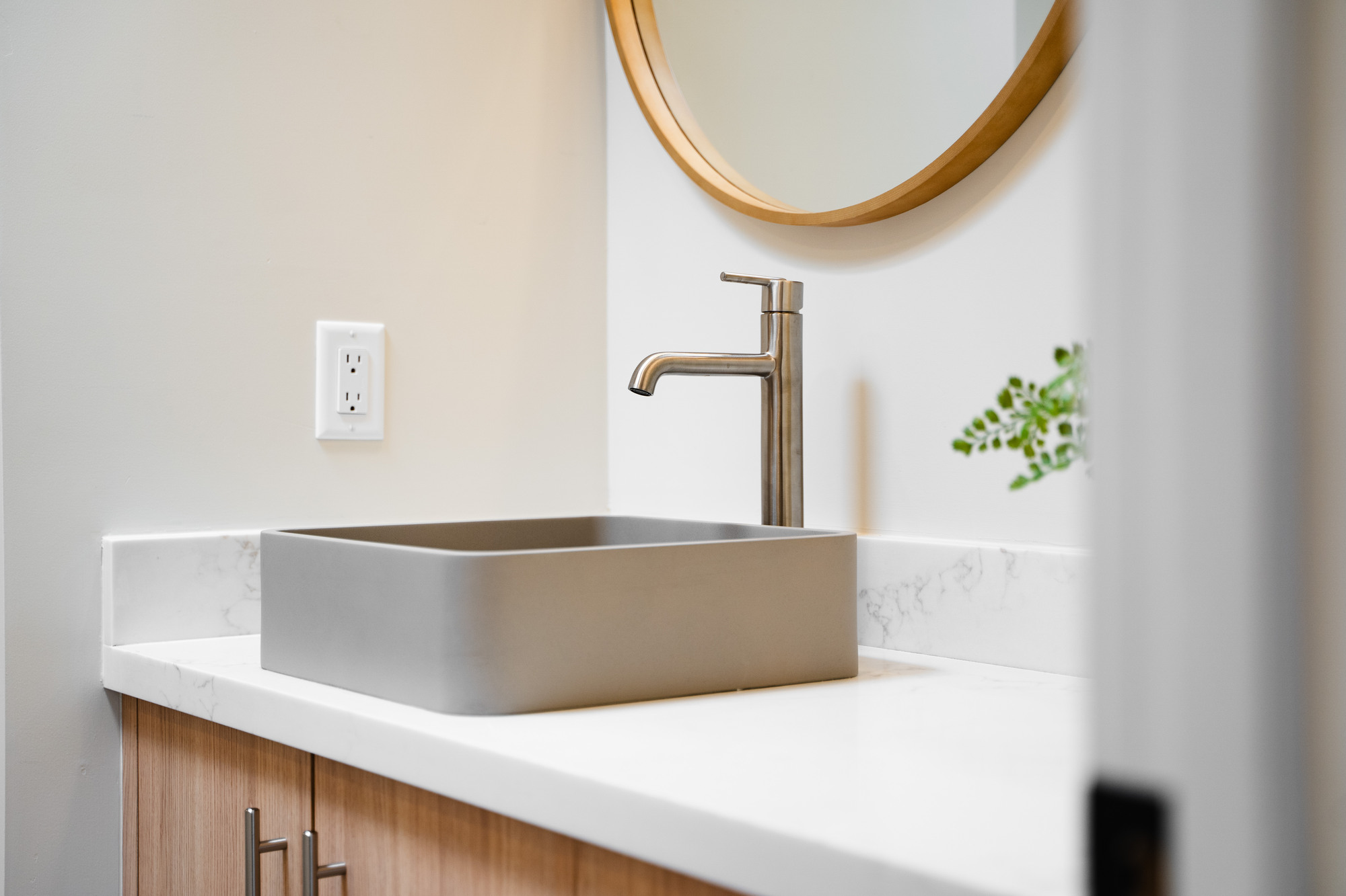 Minimalist bathroom vanity with vessel sink and round mirror in Paradise Valley remodel by Trinity Homes