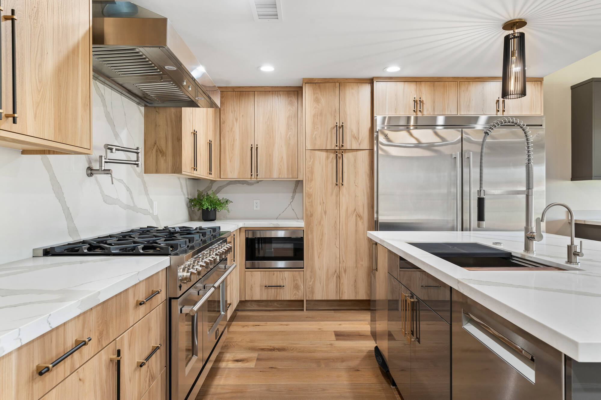 Modern kitchen remodel with light wood cabinetry and stainless steel appliances by Trinity Homes in Scottsdale, AZ
