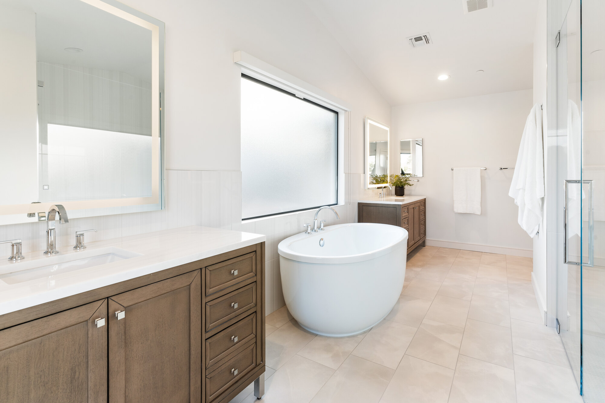 Renovated Scottsdale bathroom with custom double vanity and frameless mirror by Trinity Homes