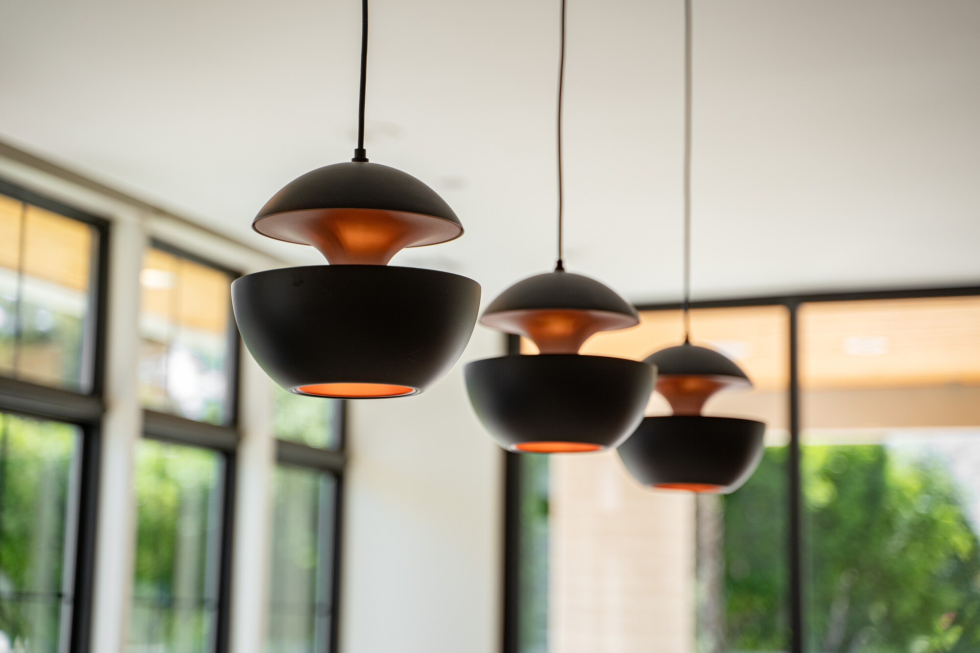 Trio of matte black pendant lights over kitchen island in Trinity Homes Paradise Valley remodel