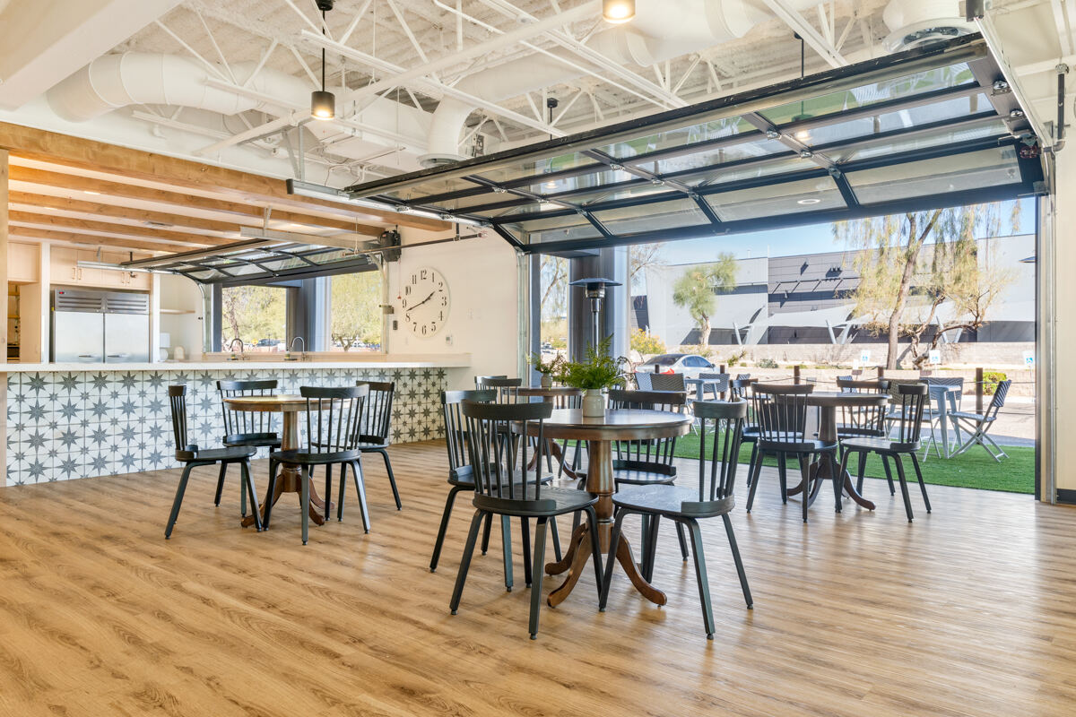 Open dining area with garage-style doors in Trinity Homes’ Scottsdale commercial renovation