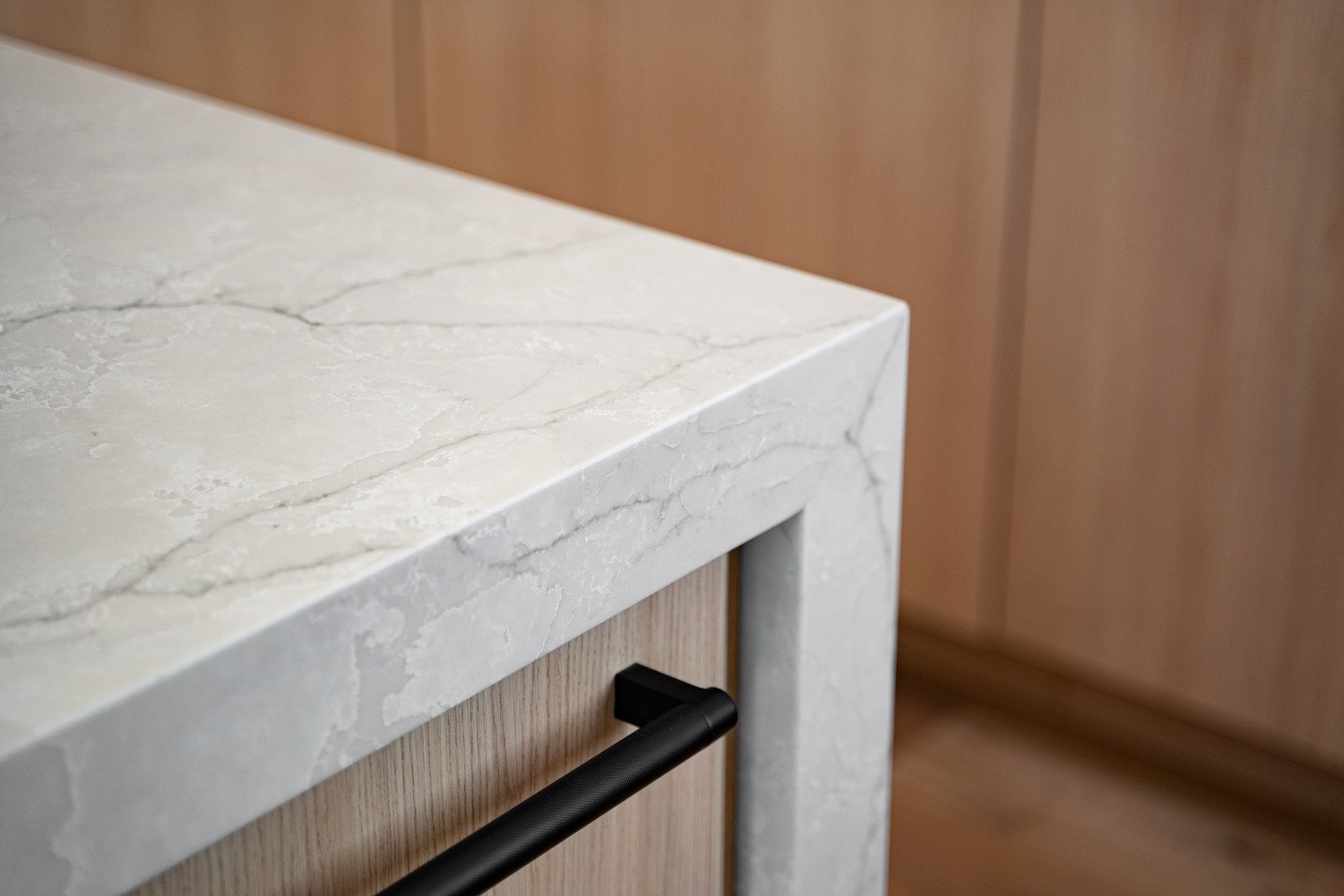 Marble-look quartz island corner with black hardware in Paradise Valley kitchen by Trinity Homes