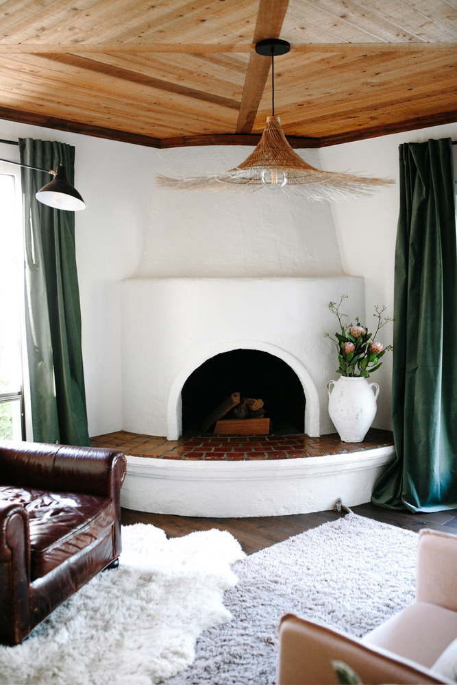 Renovated fireplace corner with arched adobe design in Phoenix by Trinity Homes