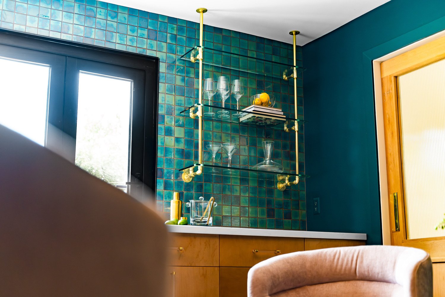 Entertainment space with teal tile and floating shelves with gold accents in Scottsdale, AZ