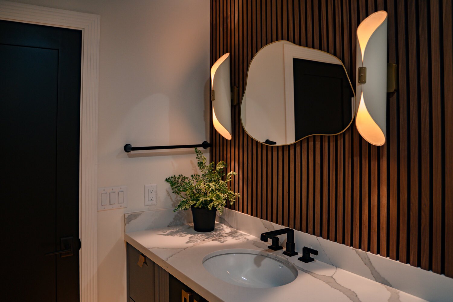 Full view of modern bathroom with black fixtures and quartz counters in a Scottsdale remodel by Trinity Homes