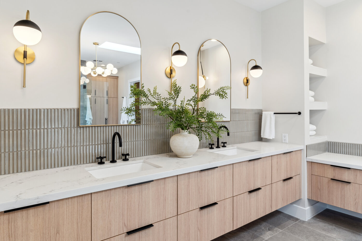 Dual vanity bathroom with modern fixtures and arched mirrors by Trinity Homes in Paradise Valley