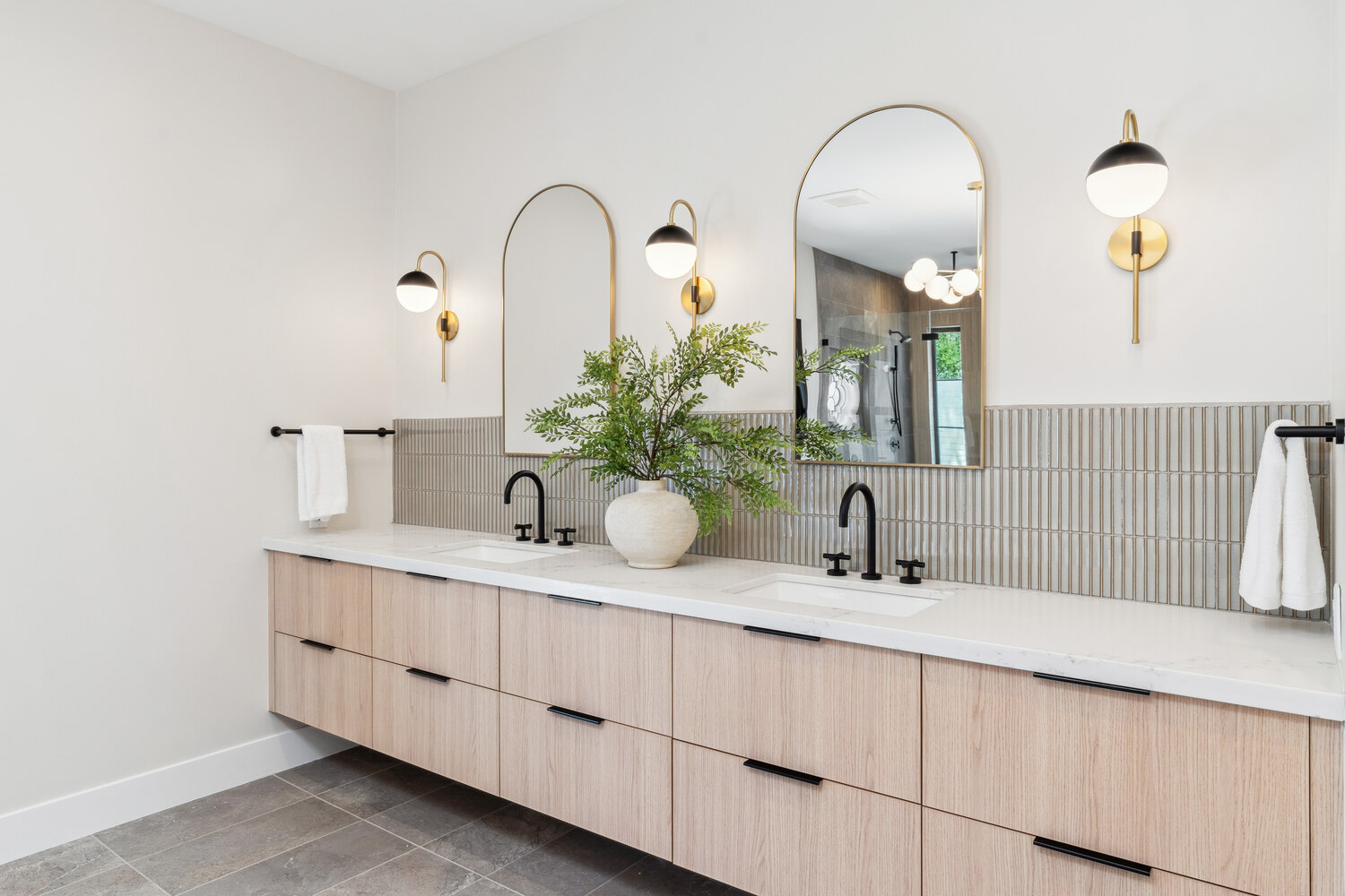 Dual-sink bathroom vanity with natural wood cabinets by Trinity Homes in Paradise Valley