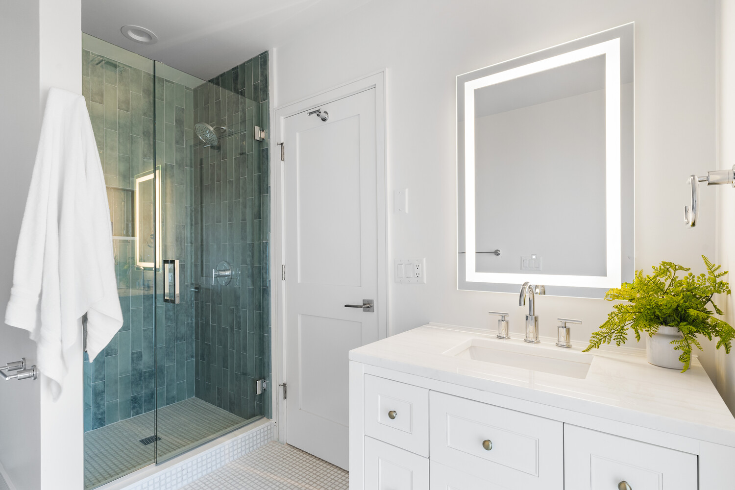 Illuminated bathroom vanity and walk-in shower in Scottsdale home remodeled by Trinity Homes