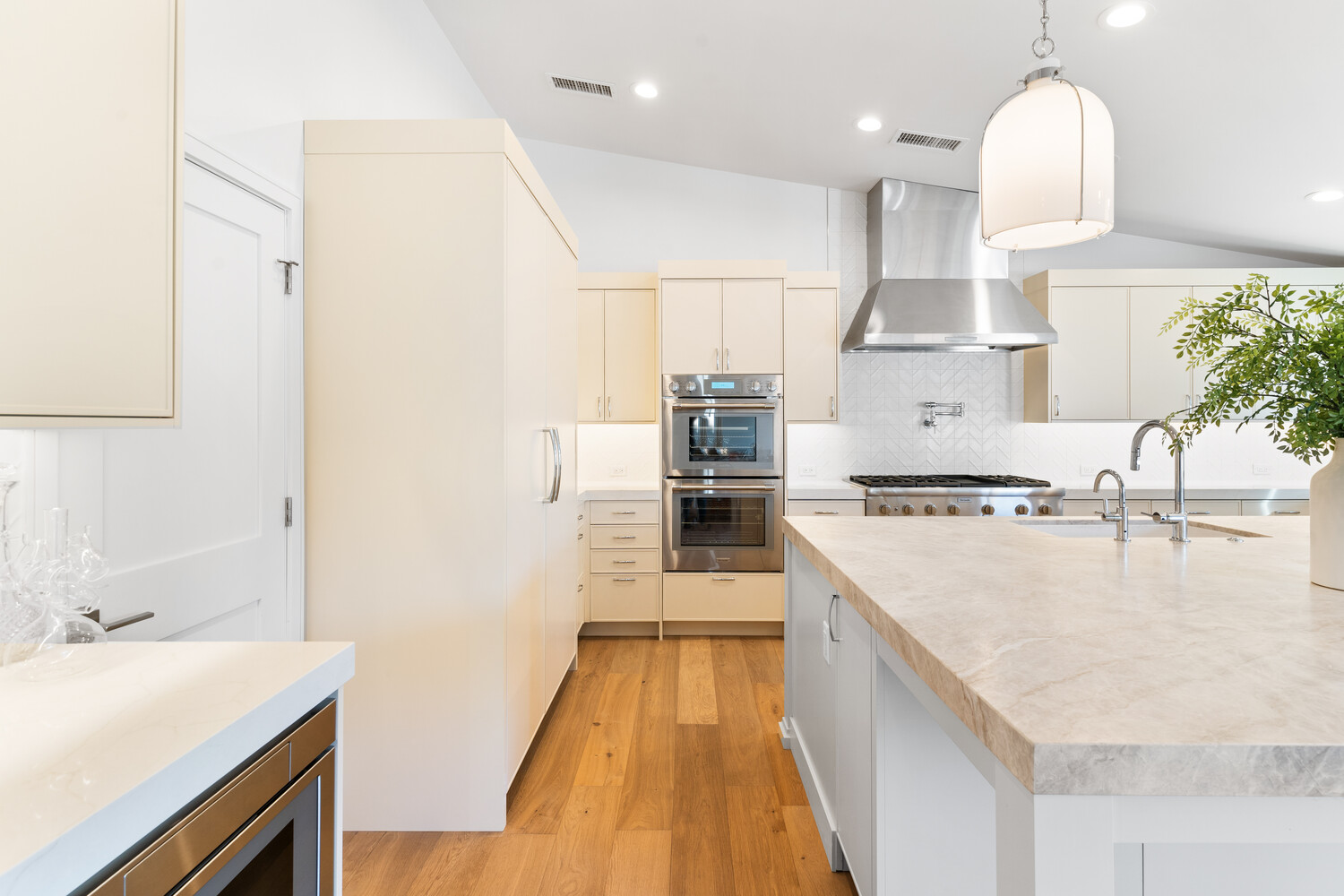 White kitchen counter with glass decanters and wood cutting board in Scottsdale home by Trinity Homes
