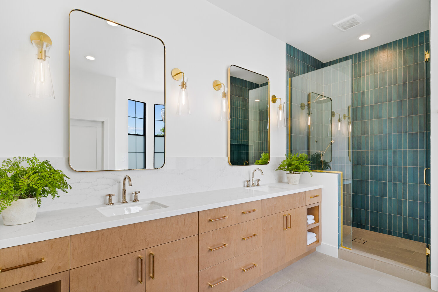 Spacious modern bathroom with gold hardware and vertical shower tile by Trinity Homes AZ in Glendale, AZ