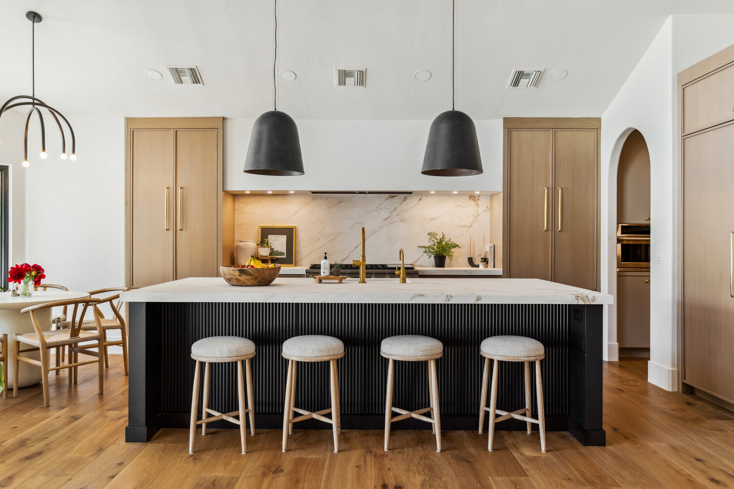 Kitchen island with bar seating and pendant lighting in Gilbert whole home remodel by Trinity Homes