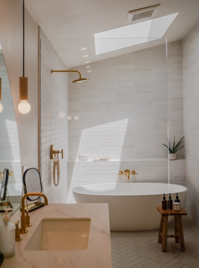 Wide view of luxury bathroom with soaking tub, walk-in shower, and gold fixtures by Trinity Homes in Gilbert, AZ-1