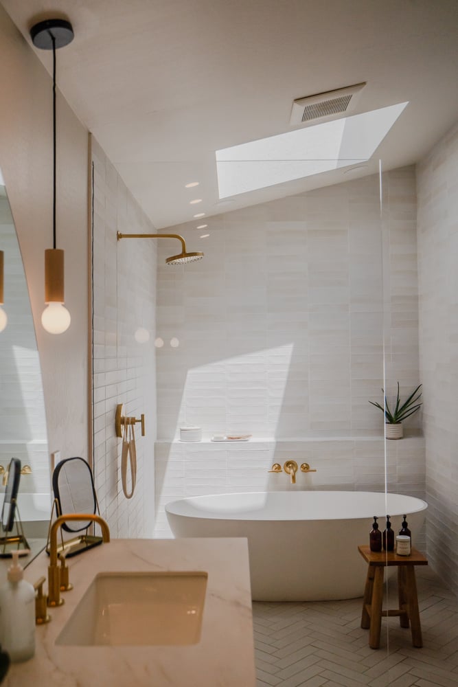 Wide view of luxury bathroom with soaking tub, walk-in shower, and gold fixtures by Trinity Homes in Gilbert, AZ