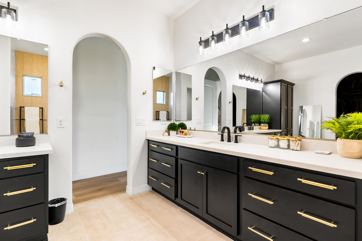Modern double vanity bathroom remodel with black cabinets and gold hardware by Trinity Homes in Phoenix, AZ